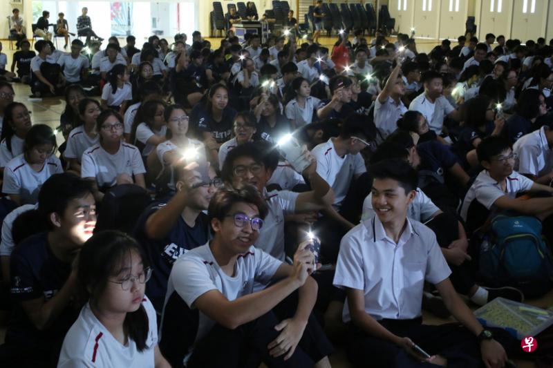 裕廊先驱初级学院学生随歌曲旋律挥动手机灯光。（梁麒麟摄）