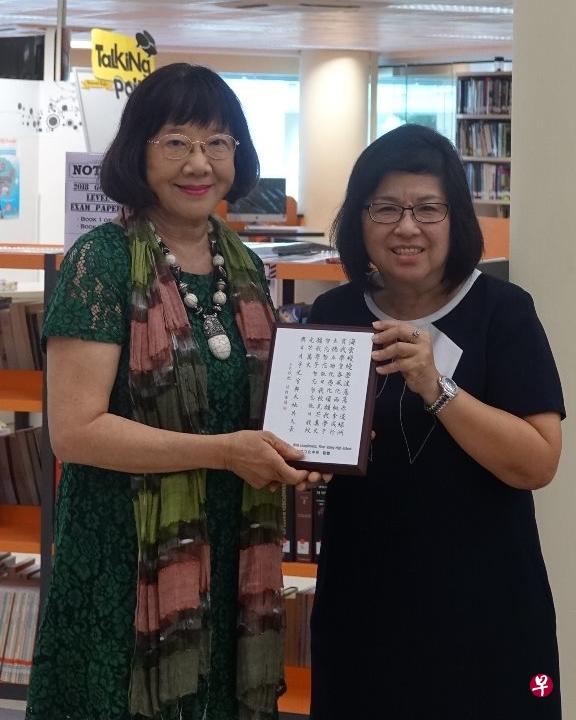 立化中学校长李惠棣（右）赠送尤今印有立化校歌的纪念品。（立化中学提供）