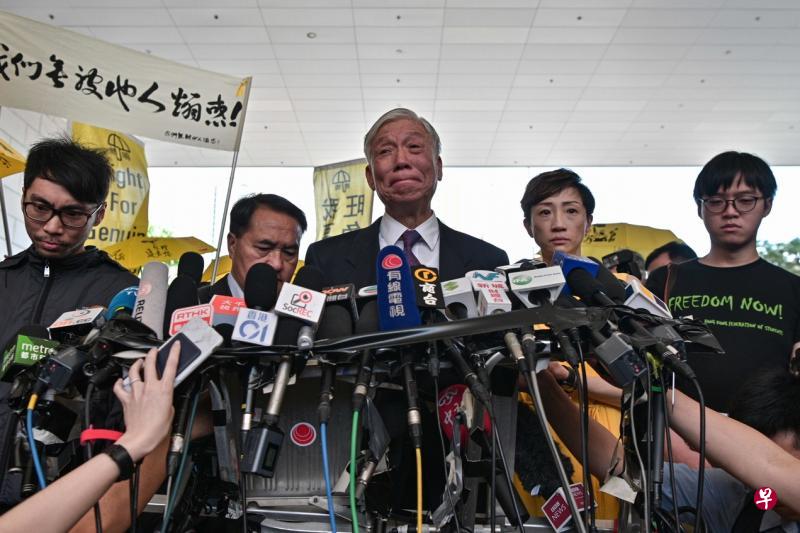 获判缓刑执行、社会服务令和押后判刑的五名被告昨天离开法庭后会见媒体，其中身为“占中三子”之一的朱耀明（中）忍不住流泪，表示对戴耀廷和陈健民被判入狱“极之难过”，自己这几年与两人从未分离，接下来他会竭尽一切的力量和办法，给予他们及其家人支持、安慰和鼓励。（法新社）