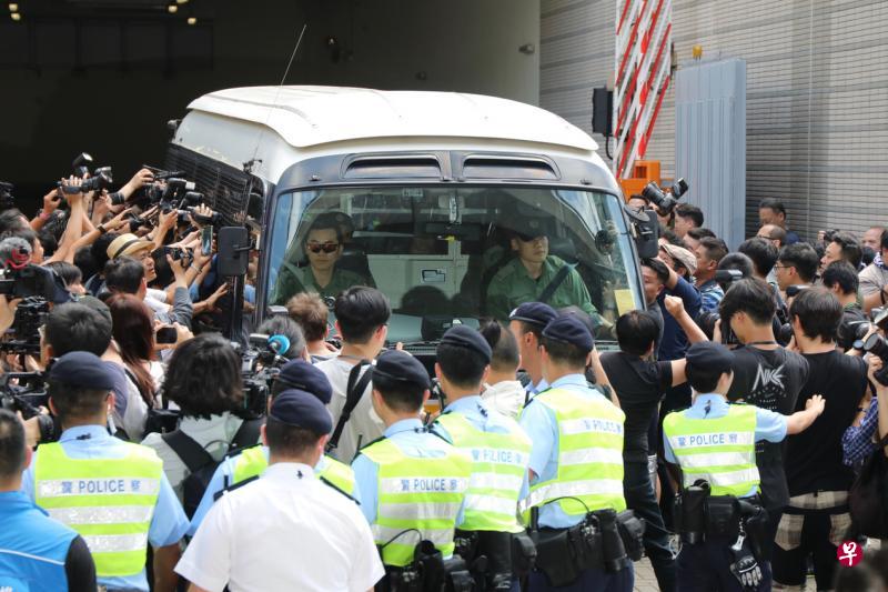 “占中”案四名被判入狱的被告昨天乘坐囚车离开香港西九龙裁判法院，其中包括“占中三子”中的两子陈健民（上图左一）与戴耀廷（上图左二）。（中通社、彭博社）