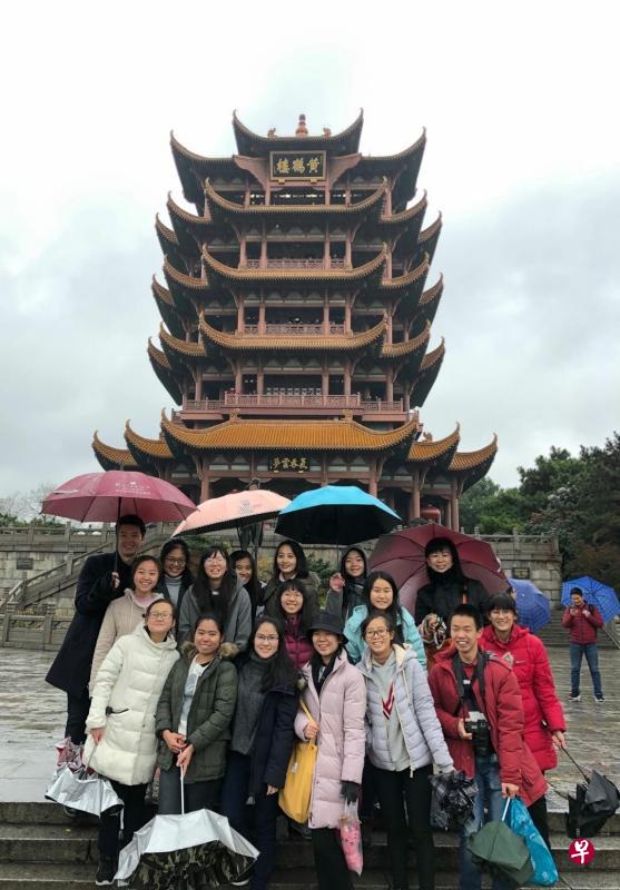 下着霏霏细雨，云雾缭绕，寒风凛冽，学生撑着伞探访黄鹤楼。（立化提供）
