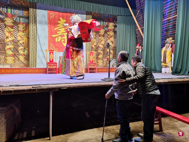 此次回乡，许家也请来潮剧团在村里演出潮戏。图为许来顺与他的父亲站在舞台前。（受访者提供）