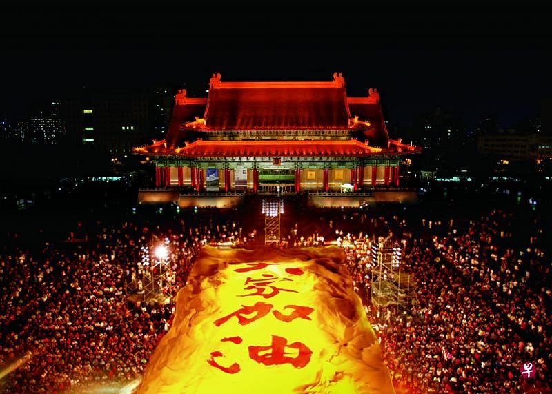 2003年云门30周年，《薪传》演出谢幕后在剧院外的广场看转播的观众同举大幅布幔，互道加油。（云门舞集提供）