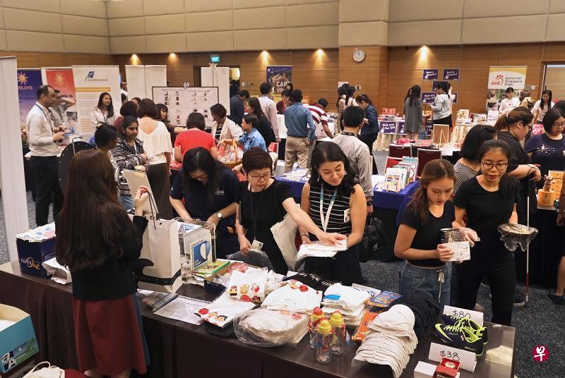 报业控股昨天在报业中心礼堂举行慈善嘉年华，为35个慈善团体筹款，获得员工踊跃支持。（何炳耀摄）