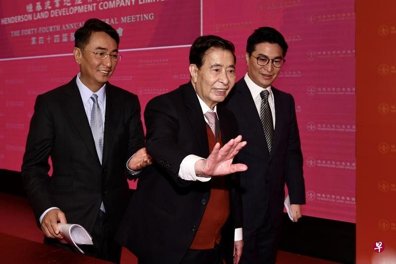 股东会结束后，恒基地产创办人李兆基（中）在儿子李家杰（左）和李家诚的搀扶下离场。（中新社）
