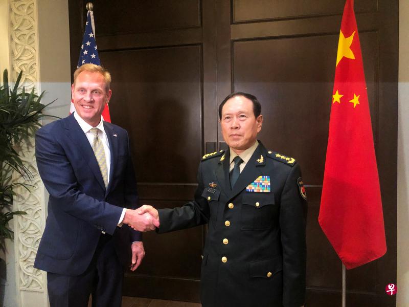 中国国防部长魏凤和（右）今天与美国代理国防部长沙纳汉在新加坡香格里拉对话会场边举行会谈。（路透社）