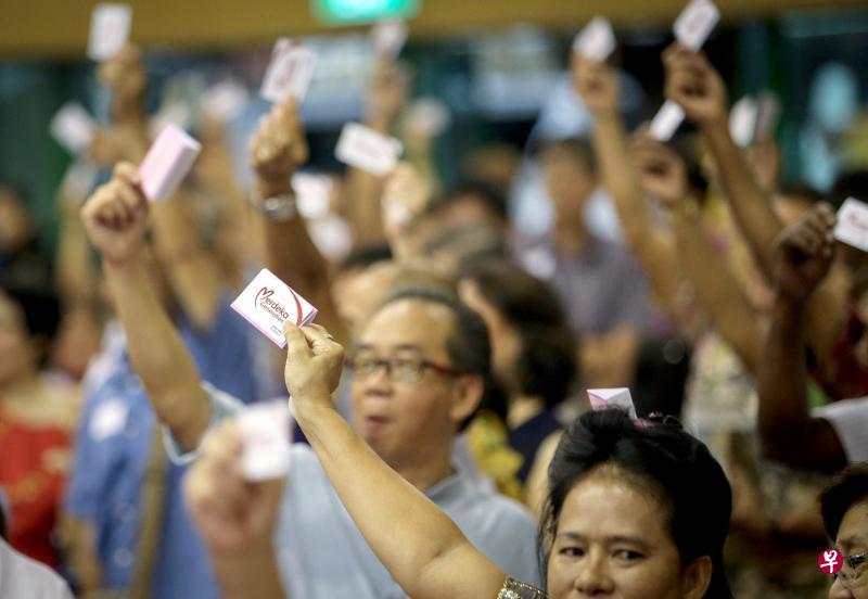 500名义顺居民率先领取立国一代福利包后，一起自豪地举起立国一代卡。（叶振忠摄）