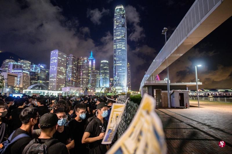 香港中环海滨一片3000平方米的土地（围栏右边）前天午夜移交解放军驻港部队。一群示威者到场抗议。（法新社）
