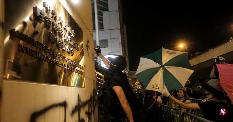 港府发言人今晚表示，强烈谴责示威者恶意包围和冲击中联办大楼。图为示威者正在涂污中联办大楼外墙。（法新社）