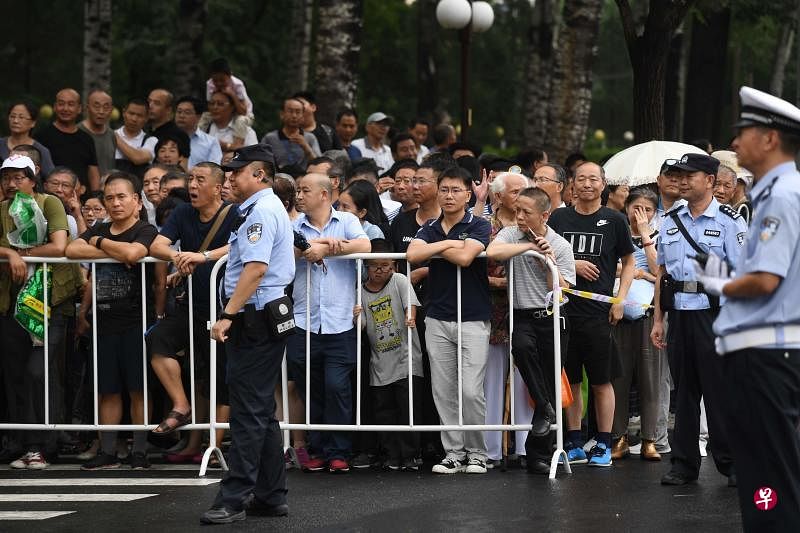 八宝山革命公墓门外驻足观看的民众。（法新社）