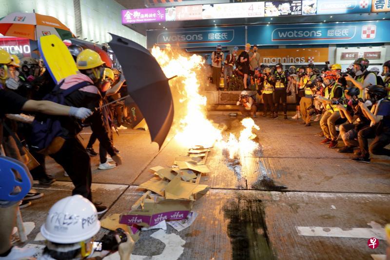 香港示威者昨晚在路上燃烧纸皮，企图形成一道屏障，与警方对峙。（美联社）