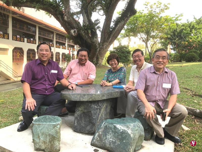 40年后，年近花甲的华初学生再约恩师，华初大树下相聚留影。（左起）许统城、林恩和、冯焕好、黄佑廉和卓裕章。（作者提供）