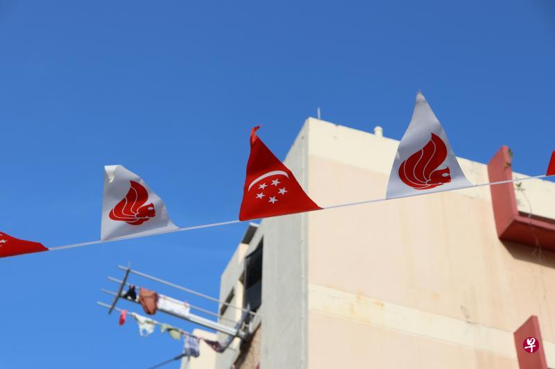 国庆日旗帜在蓝天下飘扬，照片色彩平衡。