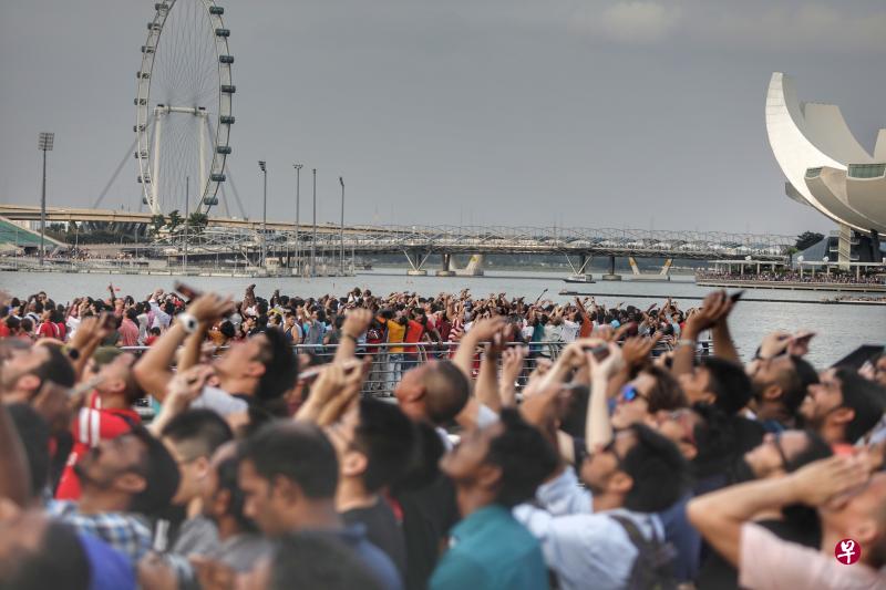 但凡海陆空出现任何风吹草动，滨海湾沿岸上万名来自国内外的观众便会整齐地转向声音来源方向，举起手中手机相机，焦灼等待惊喜出现。（林国明摄）