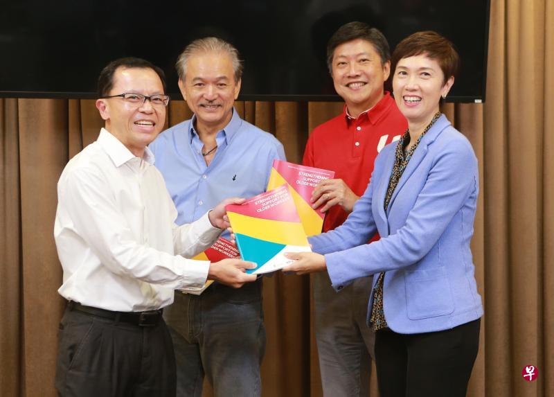 人力部常任秘书、年长员工劳资政工作小组主席甘泽铨（左一）把小组的报告交给人力部长杨莉明（右一）。全国雇主联合会会长叶进国（左二）和全国职工总会秘书长黄志明都是小组的顾问。（唐家鸿摄）