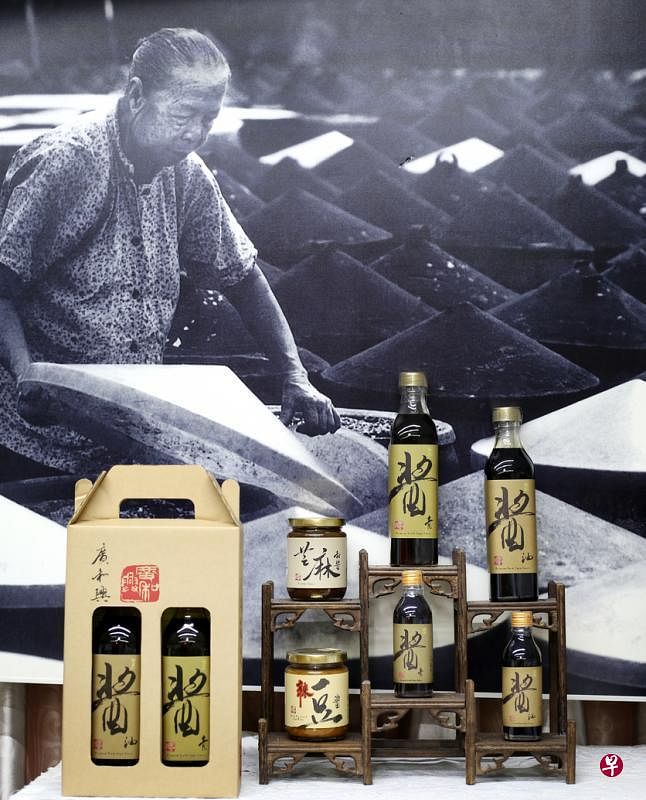 广和兴精酿系列瞄准高端市场，包装简约，20年后仍是设计经典。背景是胡镜荣的外婆。（龙国雄摄）