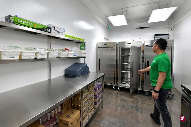 坐落在联邦通道一座组屋底层的GrabFood外卖配送中转站空间不大，设有保温柜、冷藏柜和工作台让员工处理食物。（海峡时报）