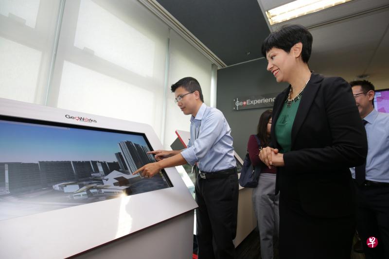 ▲土地管理局互动地图OneMap将在明年底推出新3D地图功能，让公众能以3D立体方式查看不同的建筑和路线等，土管局地理空间与数据署高级经理陈纯青博士（左一）昨天向总理公署部长兼财政部及教育部第二部长英兰妮示范这项新功能。（李薇摄）