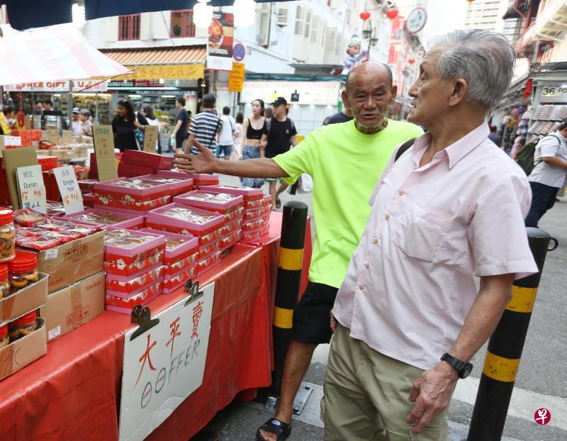 牛车水中秋市集摊贩赶在中秋节这天向顾客大力推销促销食品，希望尽快清完手上的货。（林明顺摄）