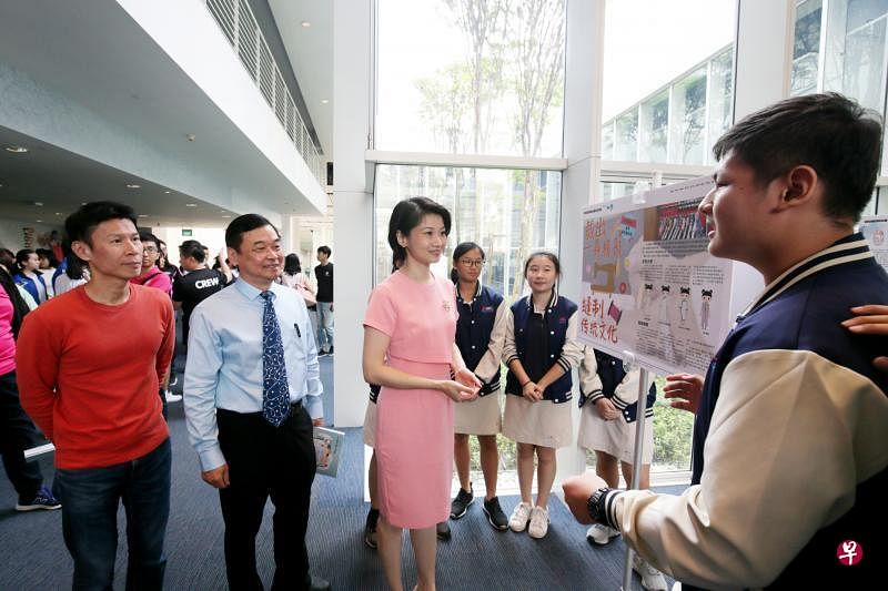 新科技中三学生贾泽宇（右一）及组员向内政部兼国家发展部高级政务次长孙雪玲（中）、推广华文学习委员会写作组组长蔡志礼博士（左二），以及本地绘本作家阿果（左一）介绍高年级组金奖作品《裁出一身精彩·缝制传统文化》的创作心得。（龙国雄摄）