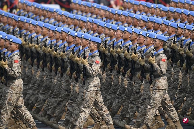 中国国庆阅兵今年首次安排维和部队方队受检，这是头戴蓝色贝雷帽，身着战斗迷彩、领口裹蓝巾的维和部队方队经过长安街。（新华社）