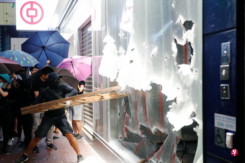 香港的抗争者打砸旺角一家中国银行支行。（路透社） 