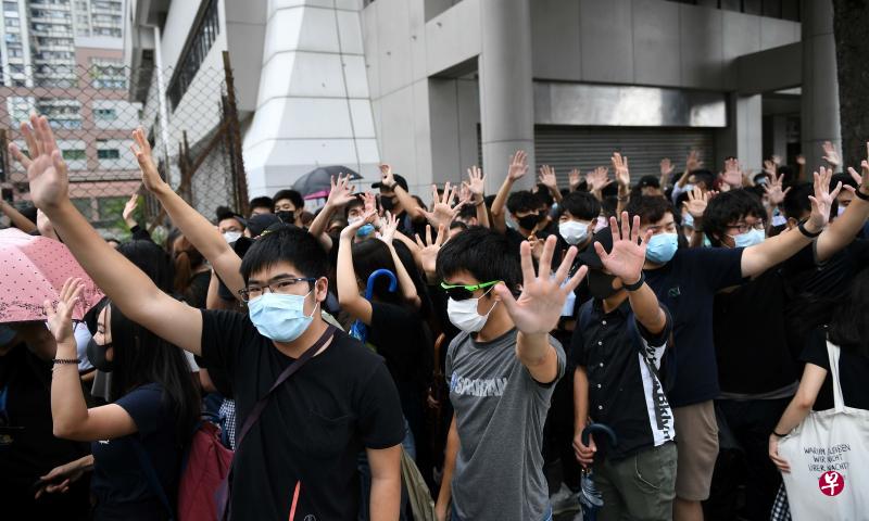 昨天上午有上百名戴口罩、穿黑衣的人士到东区裁判法院外面，声援两名被告。（法新社）