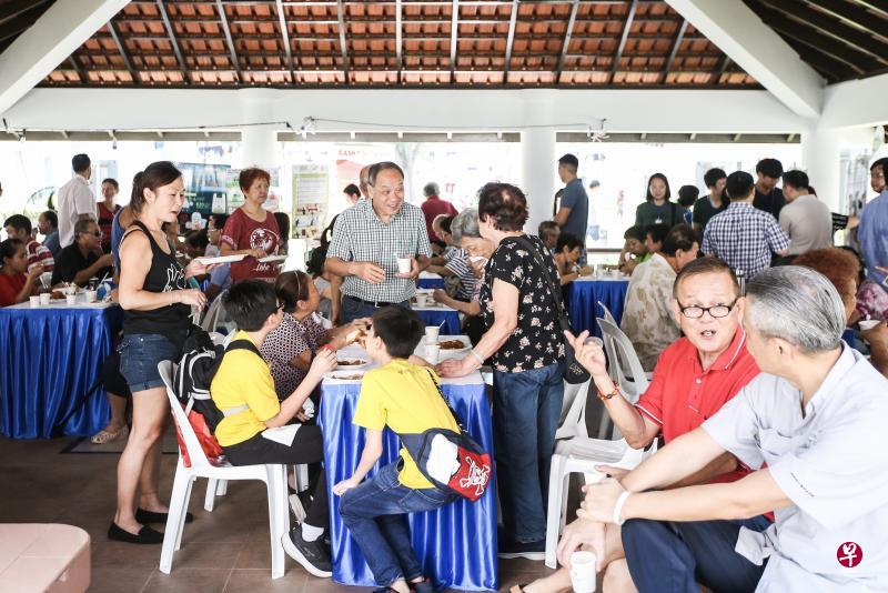 工人党前秘书长刘程强（中）星期六上午与其他工人党议员出席茶叙活动，面带笑容与居民聊天。（梁伟康摄）