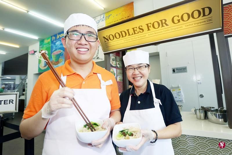 陈美凤（左）与儿子刘俊程在学校食堂卖面。（中区社区发展理事会提供）