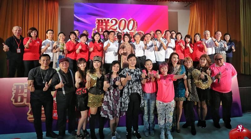 惹兰勿刹集选区议员梁莉莉医生（中排左九）与牛车水大厦小贩商联会理事及参与演出的艺人公会歌手合影。（特约陈福洲摄）