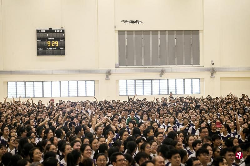 在新校舍礼堂举行创新中心的开幕仪式时，莱佛士女中学生兴奋地对空中的无人机挥手。（叶振忠摄） 