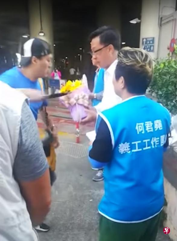 一名男子昨早佯装支持者向香港立法会议员何君尧献花，随后从包中掏出刀刺向他的左胸。这张视频截图显示，男子持刀刺向何君尧的瞬间。（中通社）