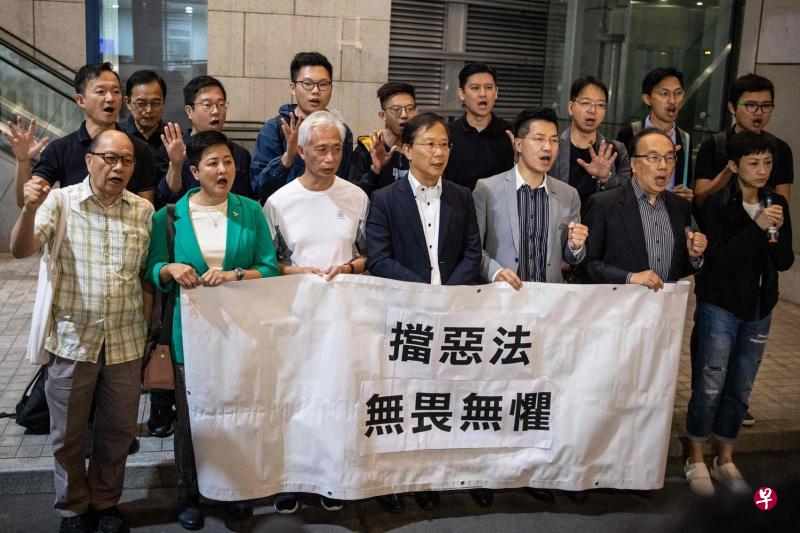香港民主派立法会议员梁耀忠（前排左三起）、郭家麒和范国威昨天到湾仔香港警察总部接受预约拘捕前，与其他民主派议员一起会见媒体。（法新社）　　