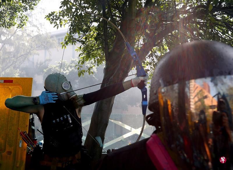 一名激进抗争者昨天下午在香港理工大学，拉弓准备射向警方。（路透社）