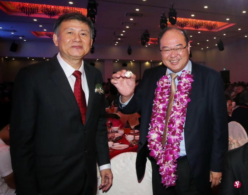 宗乡总会会长陈奕福（右）展示获赠的八卦形24K镀金纪念盾，左为苏氏公会会长苏圻国。（严宣融摄）