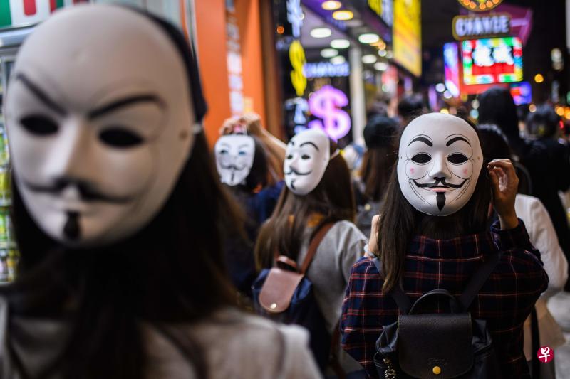 档案照，图为戴着V字仇杀队面具的香港人11月5日在九龙区参加游行。（法新社）