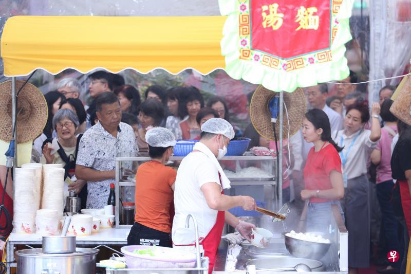大批公众在义安文化中心主办的潮州文化美食节排队领取潮汕美食。（特约李佳颖摄）