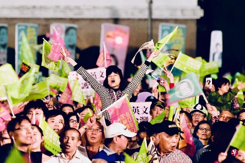 蔡英文的支持者们参加选前夜，挥舞着支持民进党和蔡英文的旗帜。（法新社）