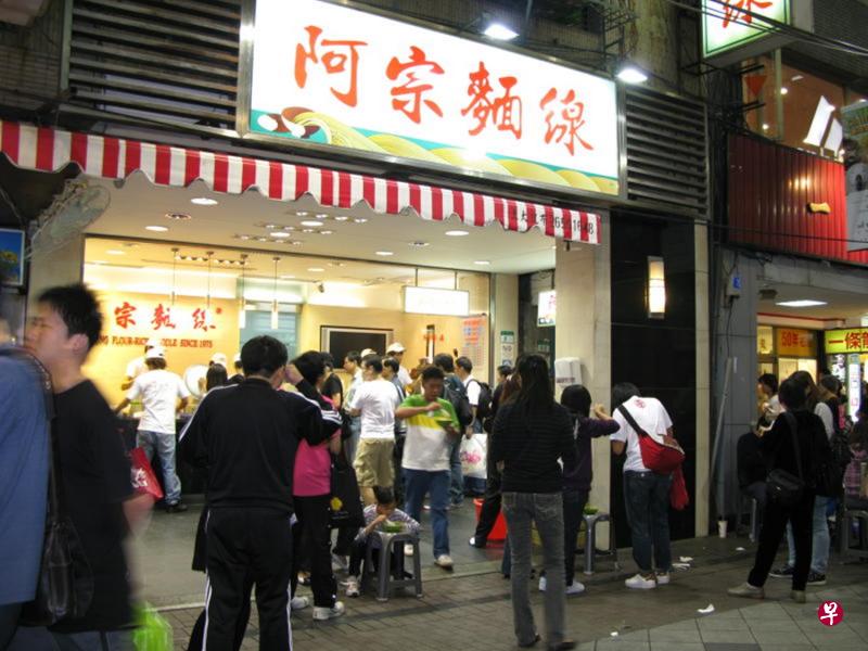在“阿宗面线”店前街道上站着用勺子舀起面线来吃的情景，已成为西门町的独特景观。（台湾观光协会）
