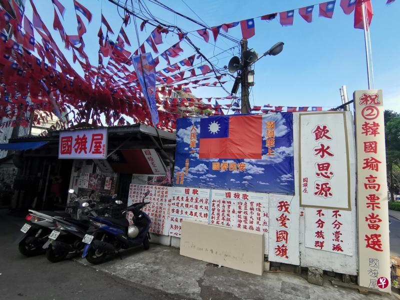 桃园县眷村忠贞新村的“国旗屋”外，售卖云南米干的老板挂起祝愿韩国瑜高票当选的标语。（温伟中摄）