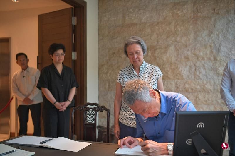 李显龙总理与夫人何晶（右一及二）昨天到前大法官杨邦孝的灵堂吊唁，并向杨邦孝的女儿、通讯及新闻部常任秘书杨颖仪（左二）表达慰问。他过后在吊唁簿上留言。（海峡时报）