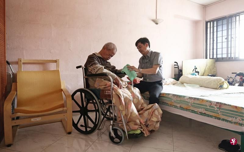 苏佩捷（右）一有空就会回家为父亲擦擦脸，按摩手脚，记性已大不如前的父亲常常会问“你是我儿子吗？”（陈渊庄摄）