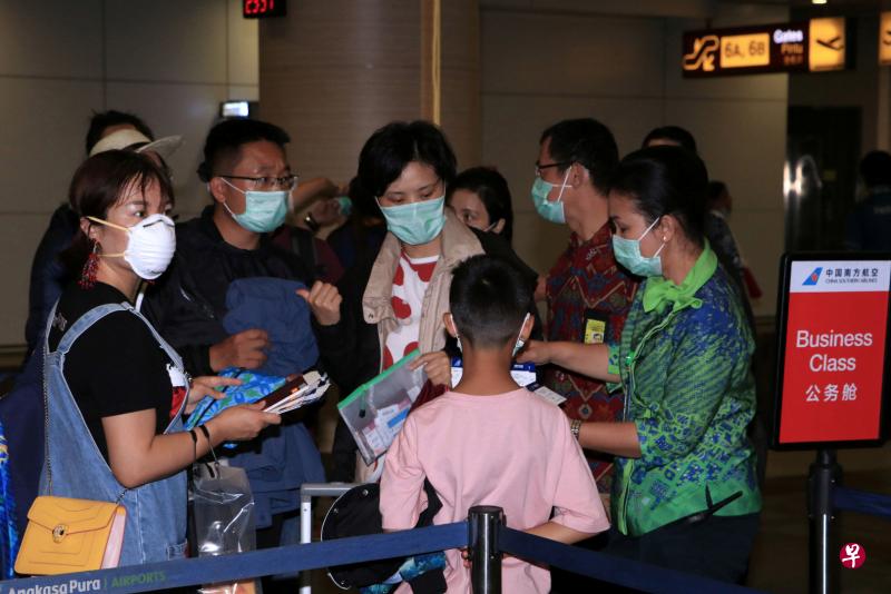 2020年2月4日，峇厘岛I Gusti Ngurah Rai国际机场人员检查南方航空飞往中国广州的航班乘客的机票。（路透社） 