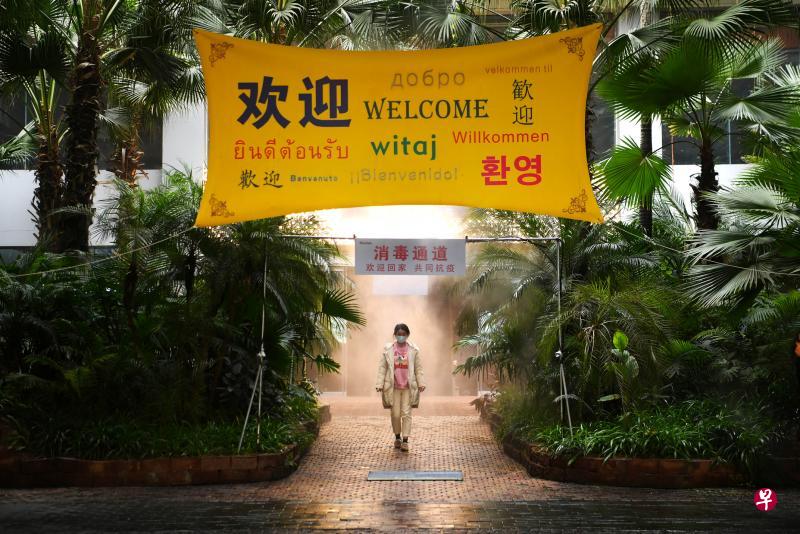 重庆一家企业设立“消毒通道”，一名员工前天经过主要入口时，自动设备会喷雾进行消毒。（路透社）