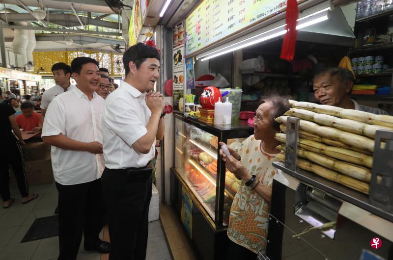　惹兰勿刹集选区议员王志豪（中）与优联燃气控股有限公司总裁张学彬（左）昨午一同到黄埔熟食中心给小贩派发洗手液。（吴伟国摄）