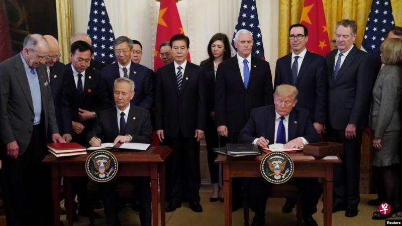 中国和美国第一阶段贸易协议周五（14日）正式生效。图为美国总统特朗普和中国副总理刘鹤今年1月15日在白宫签署协议。（路透社）