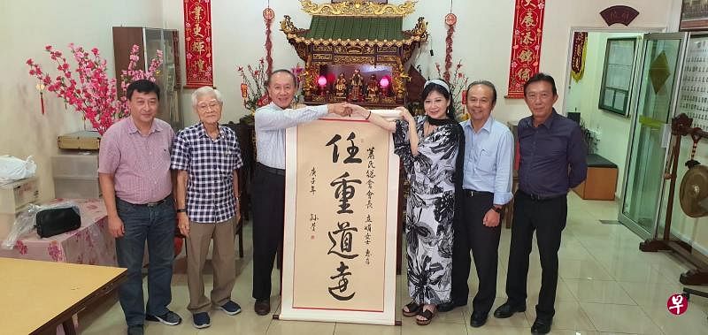 萧氏总会赠送“任重道远”勉励条幅给新理事会。左起为萧成辉、 萧衍良、萧孙庆、新会长萧立娟、萧新伟和萧怀德。（萧氏总会提供）