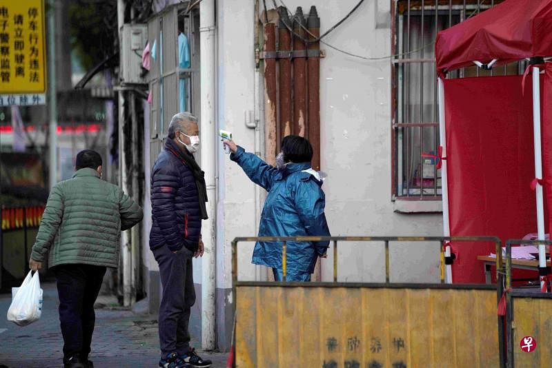 上海一街道有人检测居民体温。（路透社）