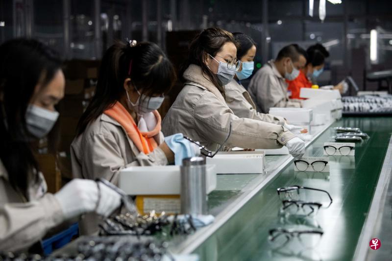 2019新型冠状病毒疾病疫情近期冲击全球供应链和经济活动，中国进出口今年首两个月双双下降。图为一群佩戴口罩的工人正在温州一家眼镜工厂工作。（法新社）