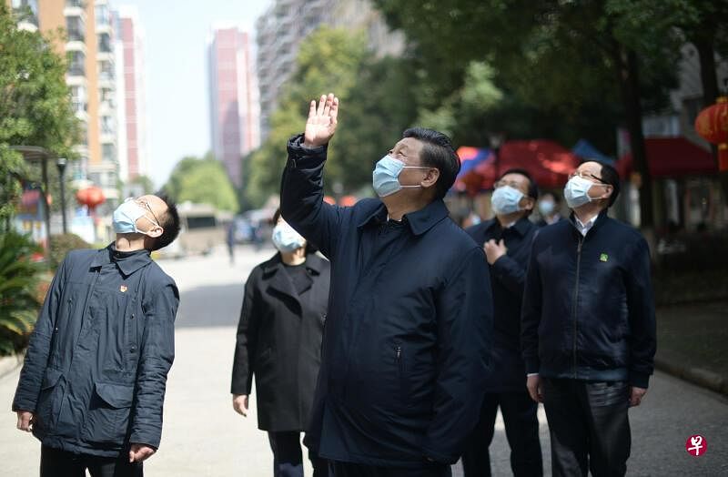 中国国家主席习近平昨天在武汉东湖新城社区考察时，向在家隔离居住的居民挥手致意。（新华社）